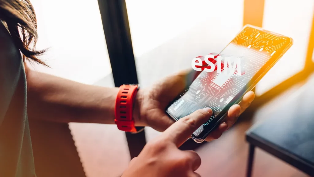 Devojka u ruci drži mobilni telefon sa prikazom esim kartice na ekranu.