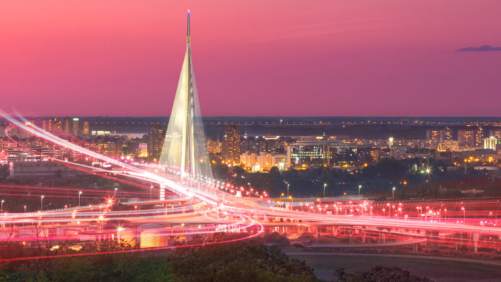 Most na Adi i panorama Beograda u sumrak sa svetlosnim tragovima optičke FiberPro internet mreže.