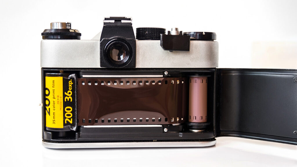 Otvoreni analogni fotoaparat sa umetnutim Kodak 35mm filmom, simbol prelaza iz analogne u digitalnu fotografiju.